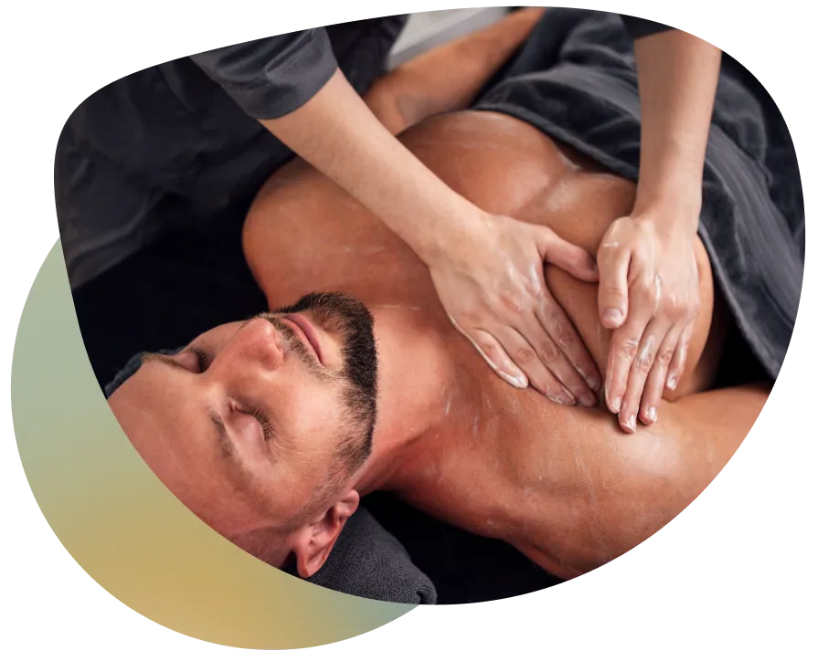 Man receiving a massage from a woman, with her hands covered in white cream, in a relaxing atmosphere.