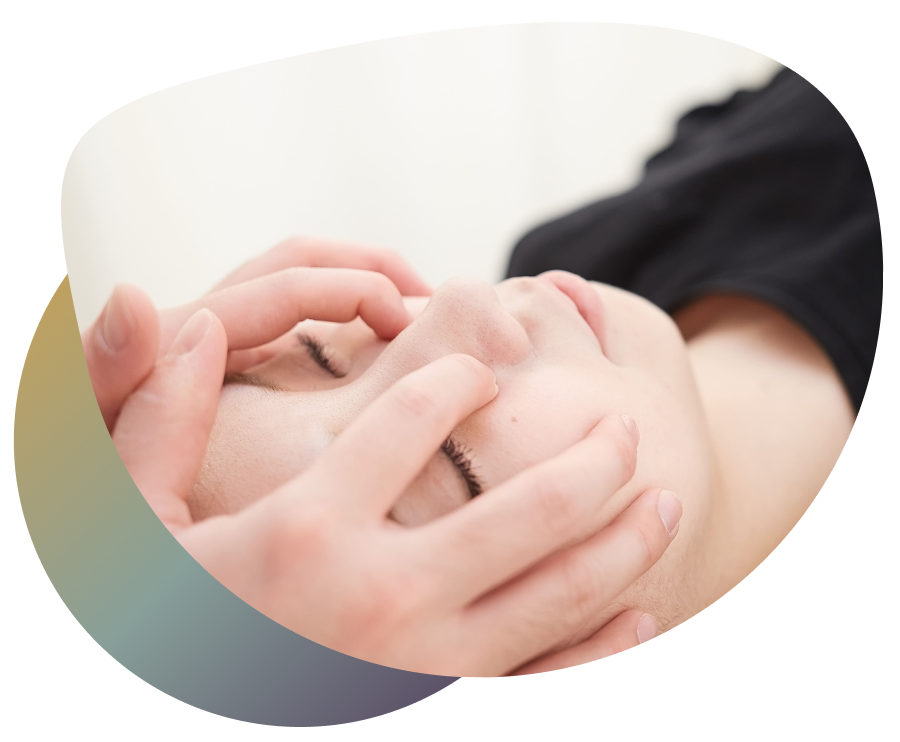 Close-up of a person's face during a facial treatment, with hands positioned around the face for relaxation and rejuvenation.