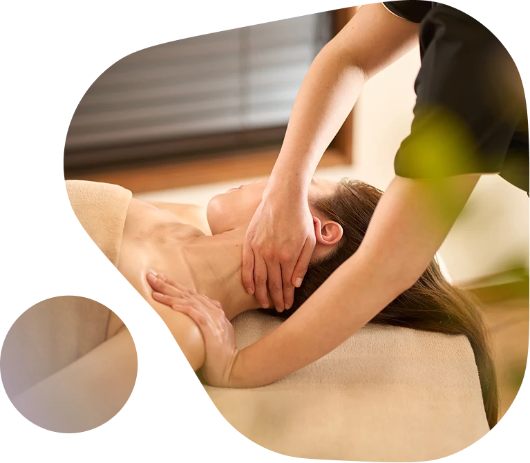 Woman receiving a massage from a therapist, with a calming atmosphere and natural light in the background.