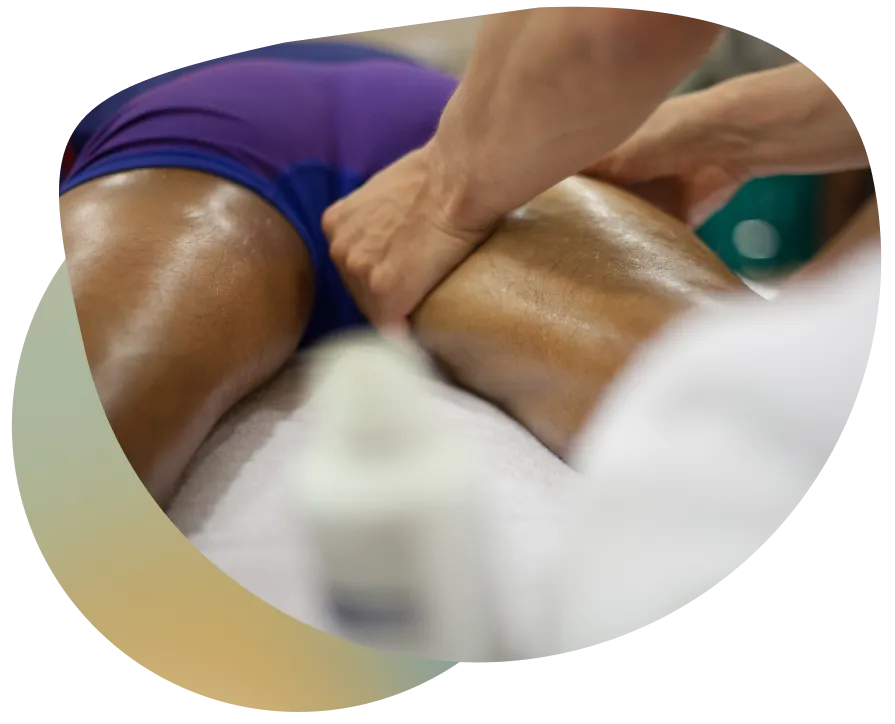 A person receiving a massage, with a focus on the therapist's hands on the client's lower back, in a calming and relaxing environment.