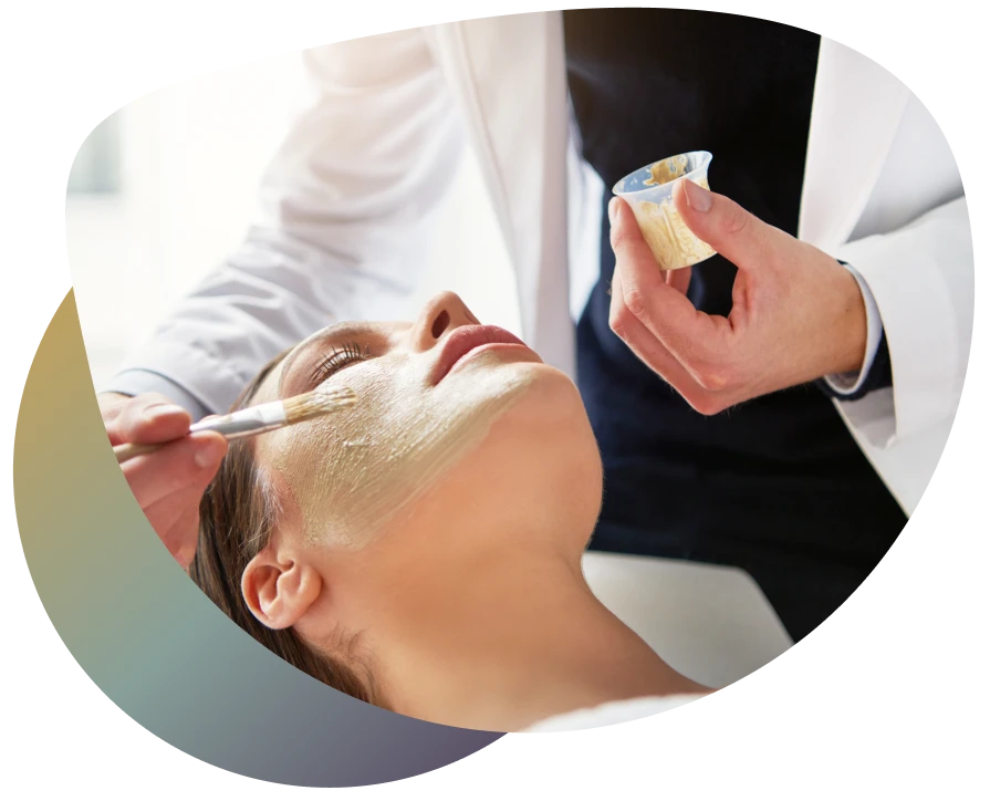 Woman receiving facial massage with organic cream on forehead