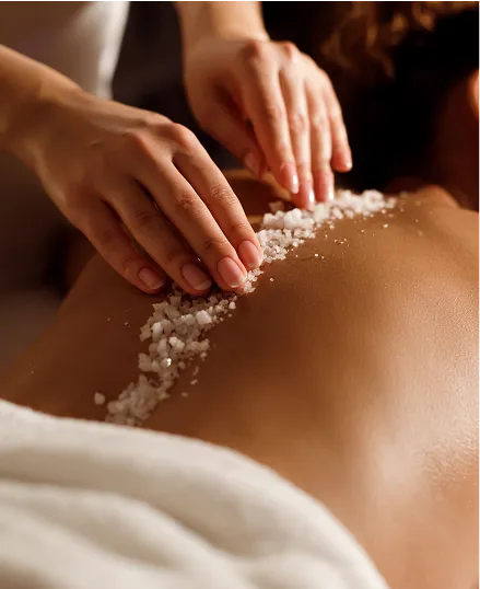 Woman receiving a magnesium scrub massage on her back.