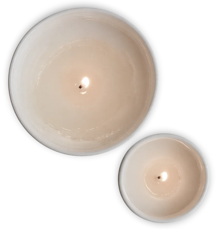 Two identical white ceramic candle holders with lit candles on a white background, featuring a beige color and small black centers.
