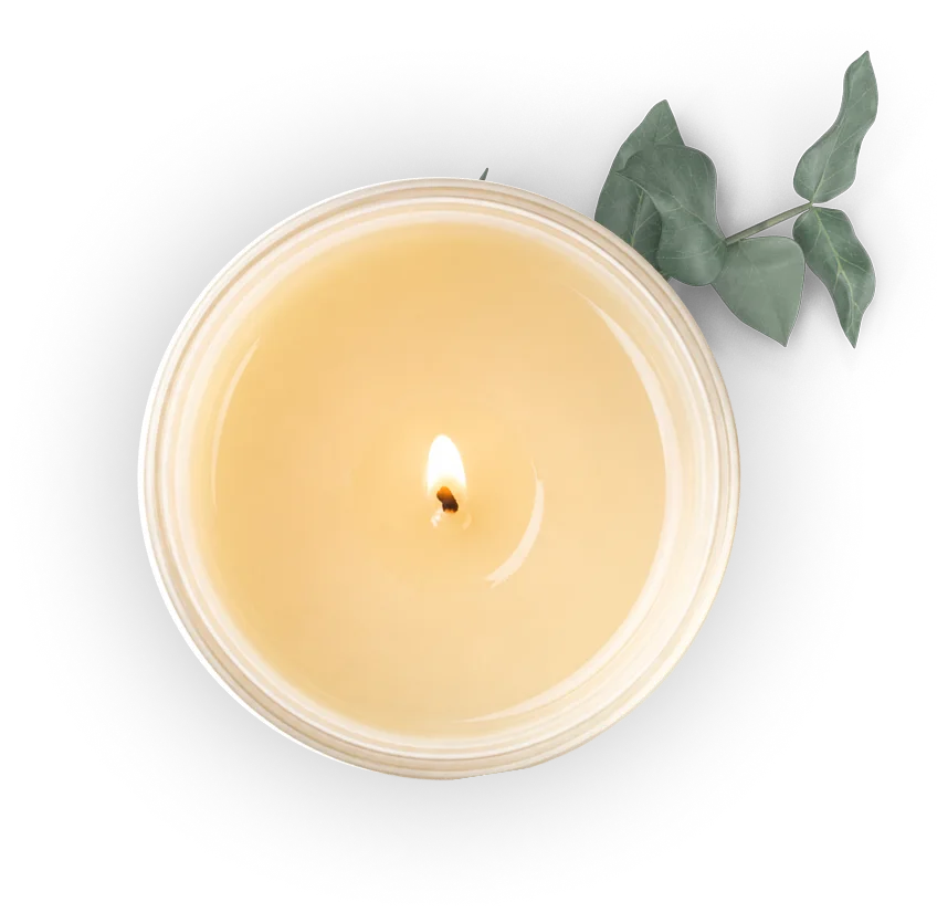 A single candle with a lit flame in a white container, with a green leaf in the background, exuding a sense of tranquility and simplicity.
