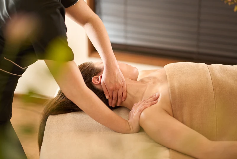 A woman receiving a massage from a therapist in a serene spa setting