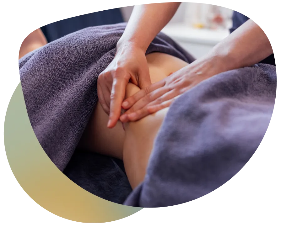 A person receiving a massage on their lower back by a professional therapist.
